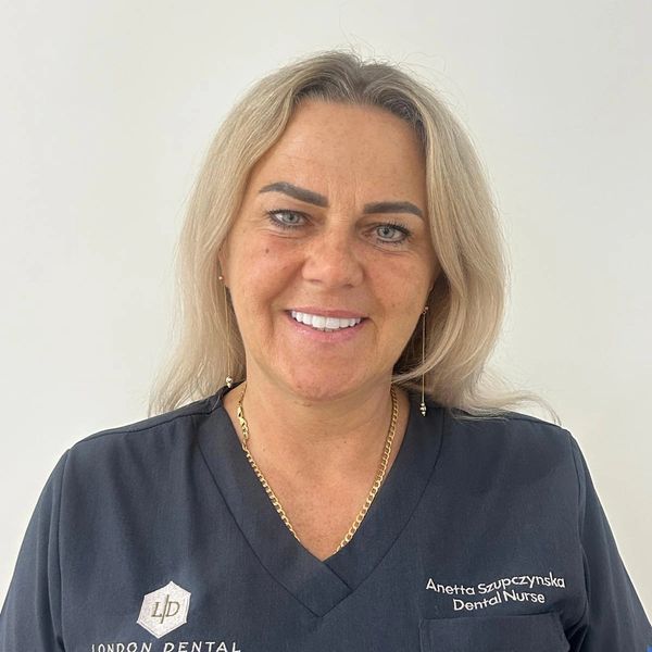 Smiling dental nurse in London Dental Implant uniform.
