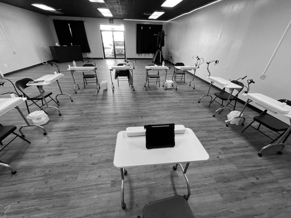 Empty classroom with spaced desks and chairs.