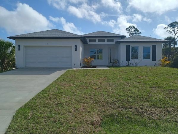 Modern single-story house with a three-car garage and a large front lawn.
