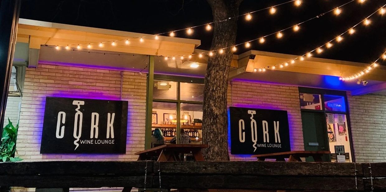 Night view of Cork Wine Lounge exterior with string lights.