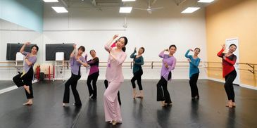 Group of women practicing traditional dance in a studio.