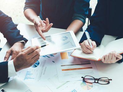 business advisor meeting to analyze and discuss the financial report situation in the boardroom.