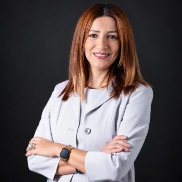 Confident woman with red hair smiling in professional attire.