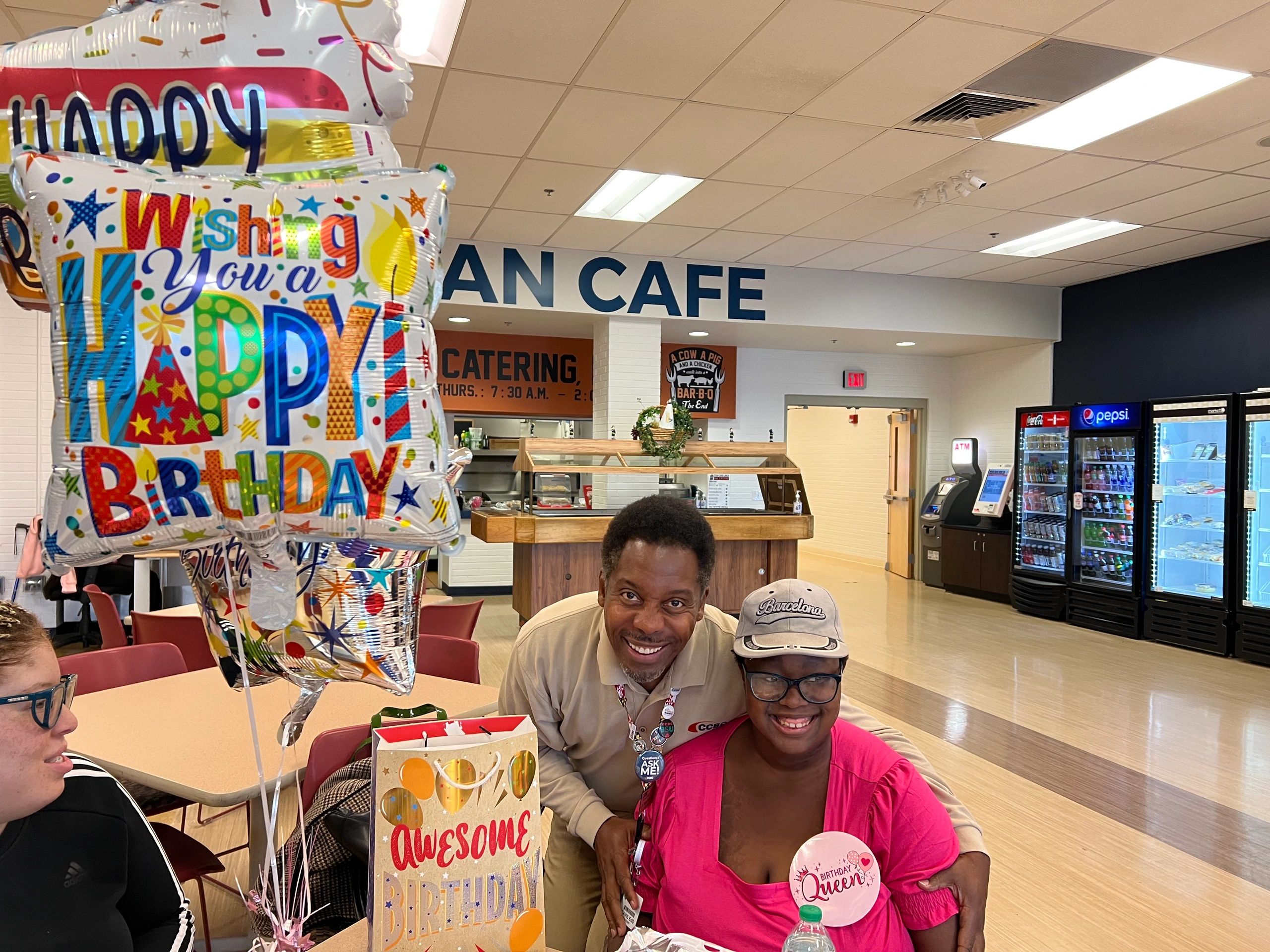 A birthday celebration in a cafe with balloons and gifts.