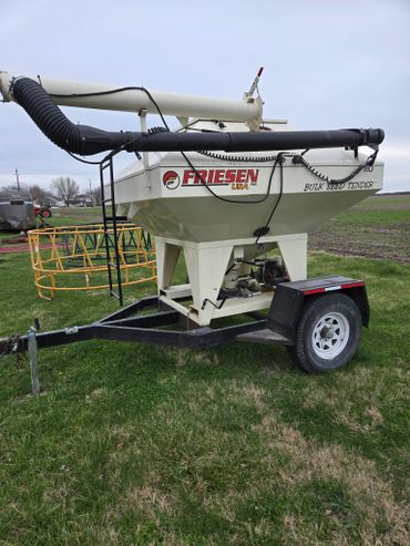 A Friesen bulk seed tender trailer parked on grass.