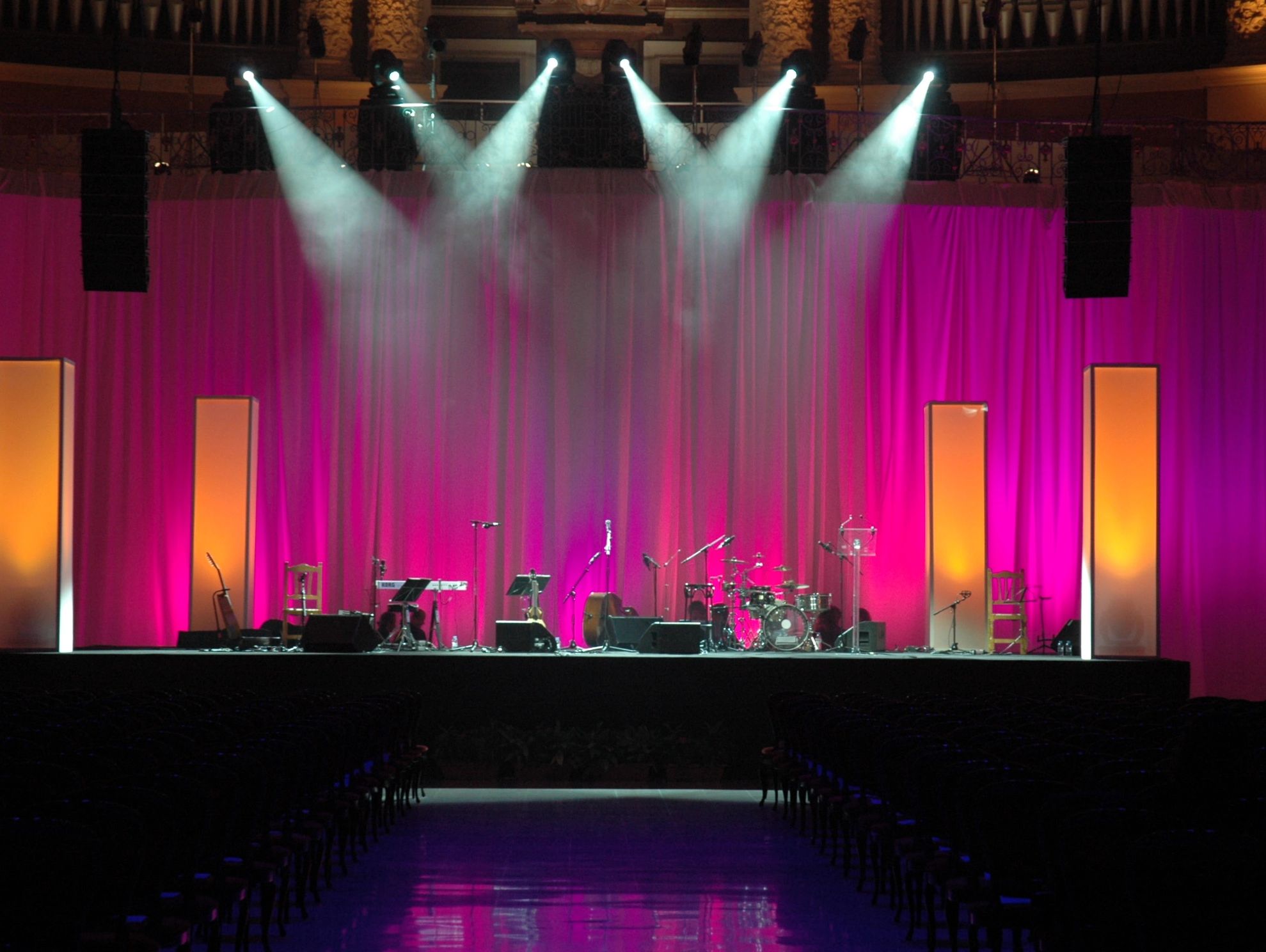 Empty stage with musical instruments and spotlight beams.