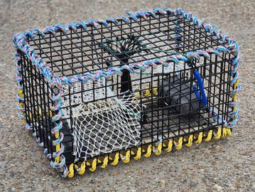 A lobster trap on concrete ground.