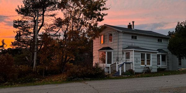 White house at sunset with autumn trees around.