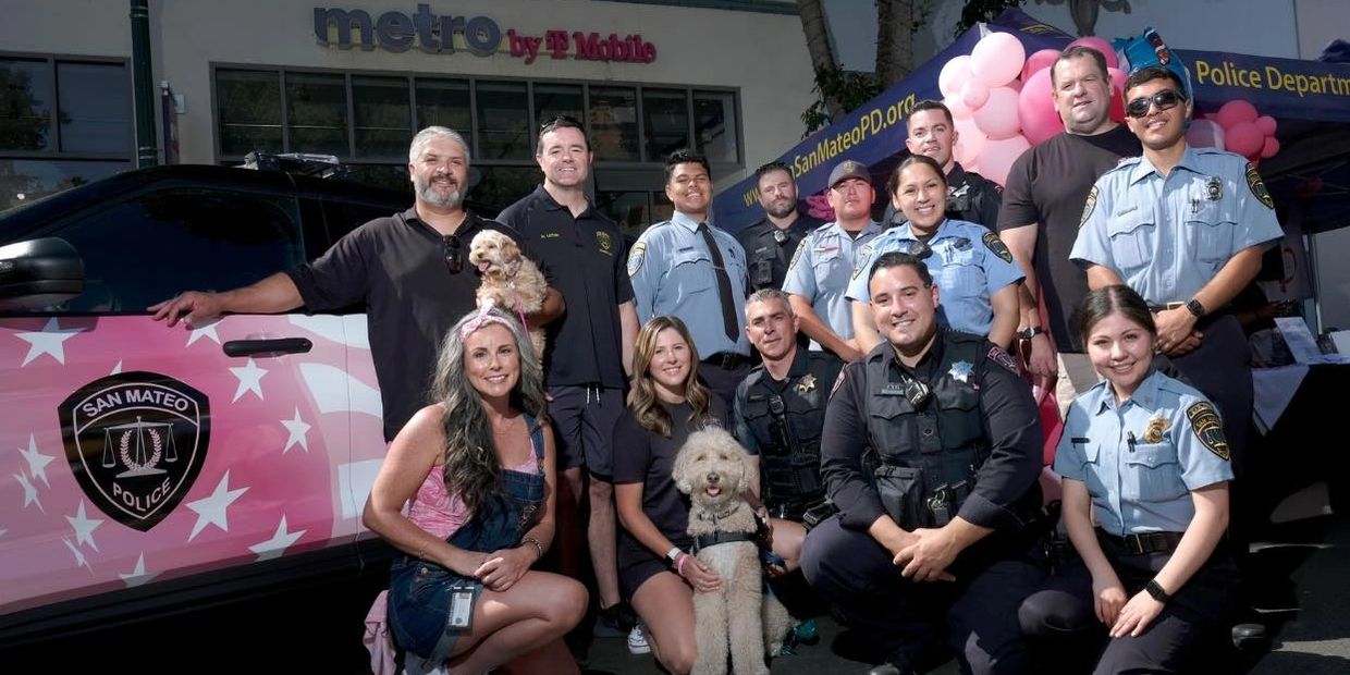 Group photo of San Mateo police officers and community members with dogs.