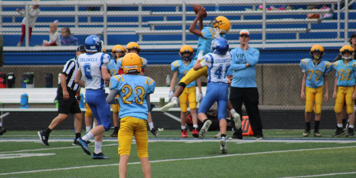 Youth football players in action on the field.