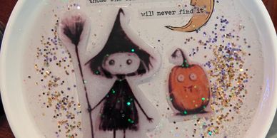 Halloween-themed artwork with a witch and a pumpkin.