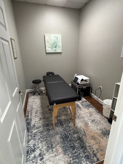 Minimalist therapy or massage room with black table and soft lighting.