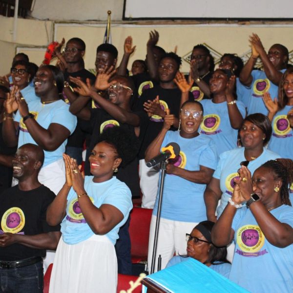 A joyful group clapping and cheering in matching event shirts.