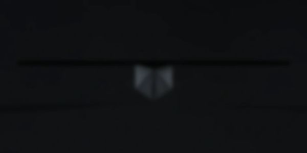 Blurry dark image with a faint, indistinct shape in the center.