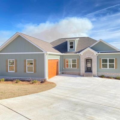New modern house with a clear driveway and a cloudy blue sky.