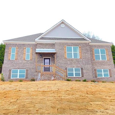 New brick house with wooden shutters and a front porch staircase.