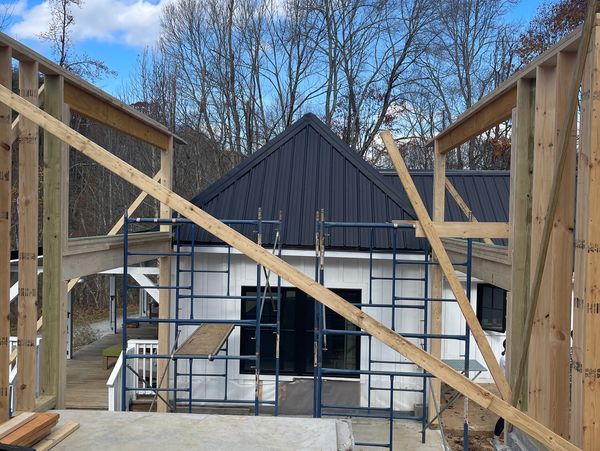 Construction site with wooden framing and scaffolding against a blue sky.