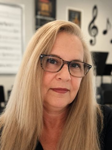Woman with glasses and long blonde hair.