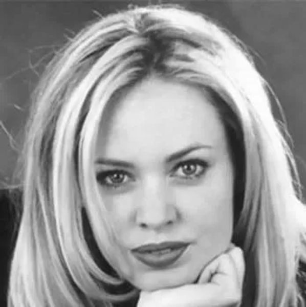 Black and white close-up portrait of a woman resting her chin on her hand.