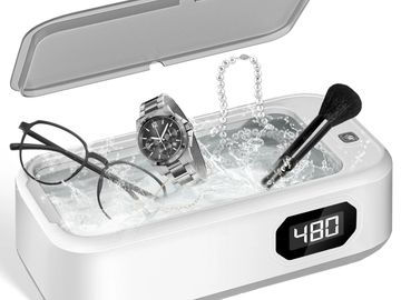 Ultrasonic cleaner with glasses, watch, necklace, and makeup brush inside.