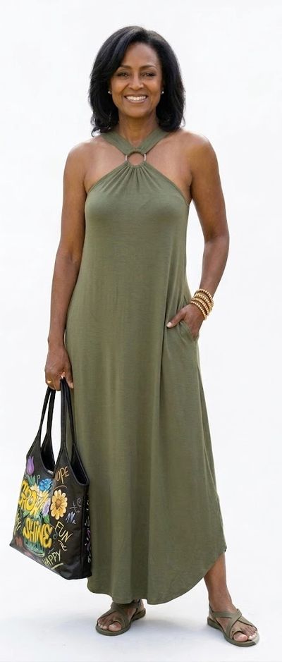Woman in olive green halter maxi dress with a colorful tote bag.