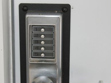 Close-up of a keypad door lock with numbers 1 to 5 on a white door.