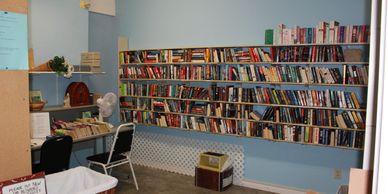 Small community library room with bookshelves and chairs.