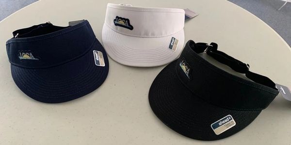 Three visors in navy, white, and black on a table.