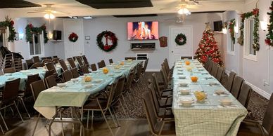 Festive dining room with Christmas decorations and tables set for a meal.