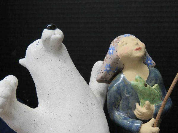 Inuit inspired with a humorous twist, this sculpture portrays a fishing girl and Polar Bear celebrat