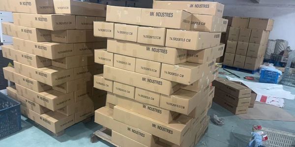 Stacks of cardboard boxes labeled MK Industries in a warehouse.