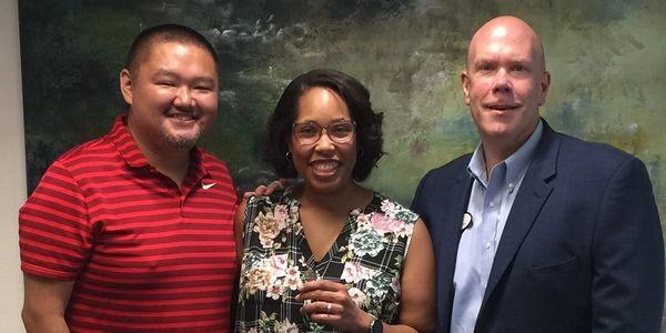 Steve Jamski poses with clients, Tiffany and Brian, at the closing of their new home.