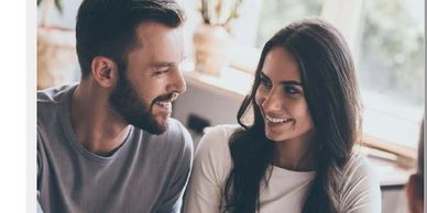 A couple shares a smile while discussing their home.