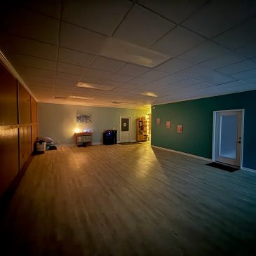 Dimly lit, spacious room with shelves and minimal decorations.
