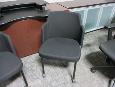 Black office chair with armrests on a carpeted floor.