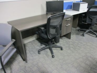 Empty office workstations with chairs and desks.