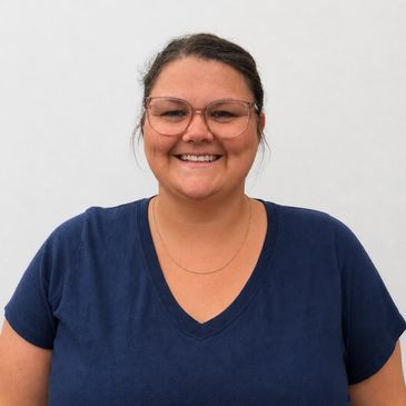 Smiling woman wearing glasses and a navy blue shirt.