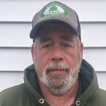 Man wearing a cap and green hoodie.