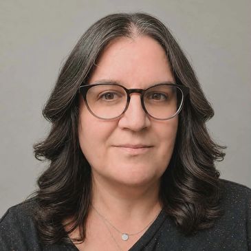 Woman with shoulder-length dark hair and glasses.