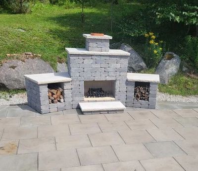 Outdoor stone fireplace with wood storage on both sides.