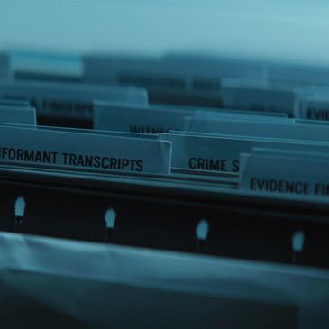 Close-up of organized file folders with labels related to crime investigation.
