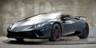 Sleek gray Lamborghini sports car with Italian flag stripe under studio lighting.