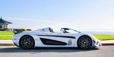Sleek white convertible sports car parked by the seaside.