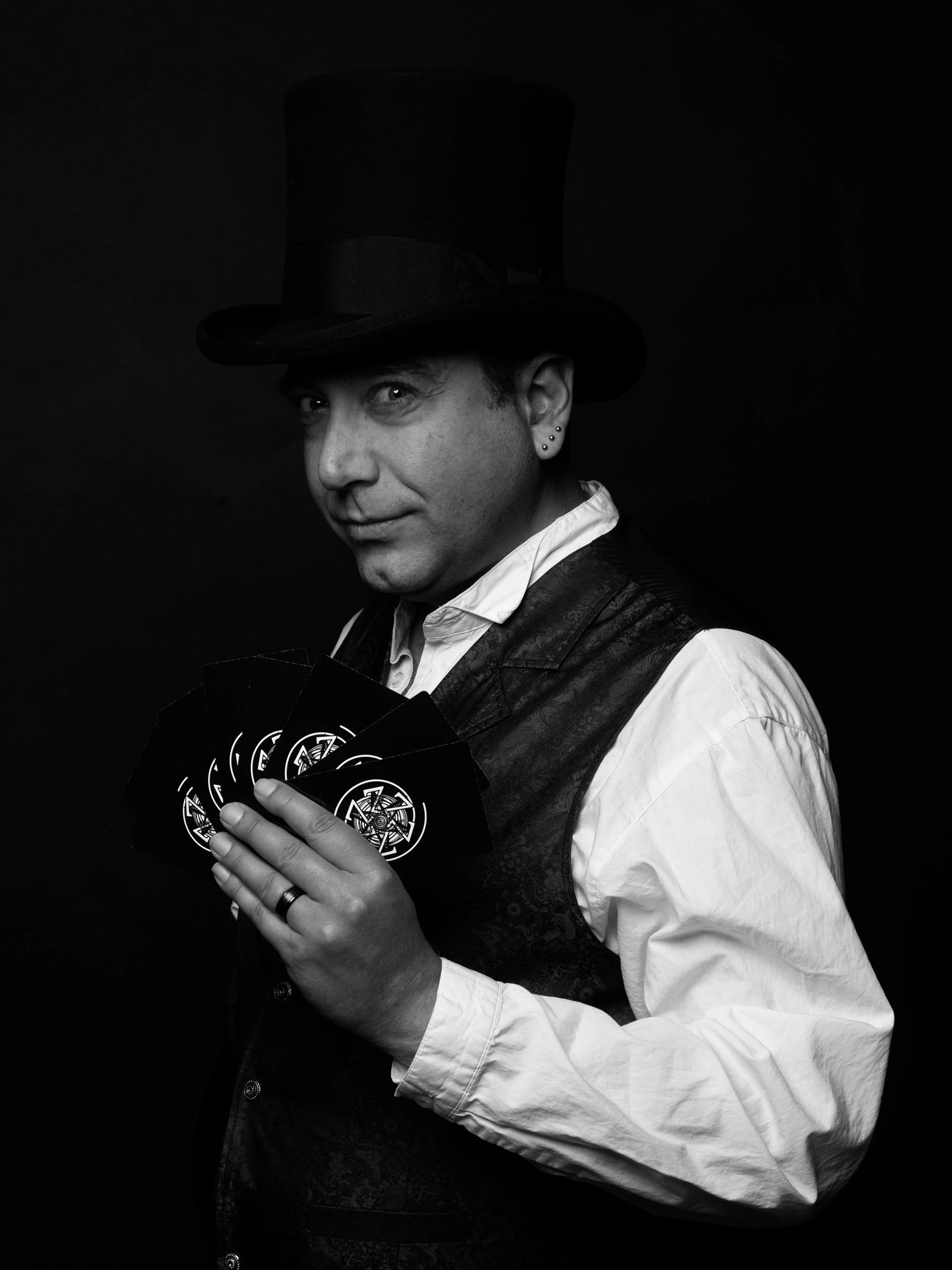 Man in top hat holding fan of cards, black and white.