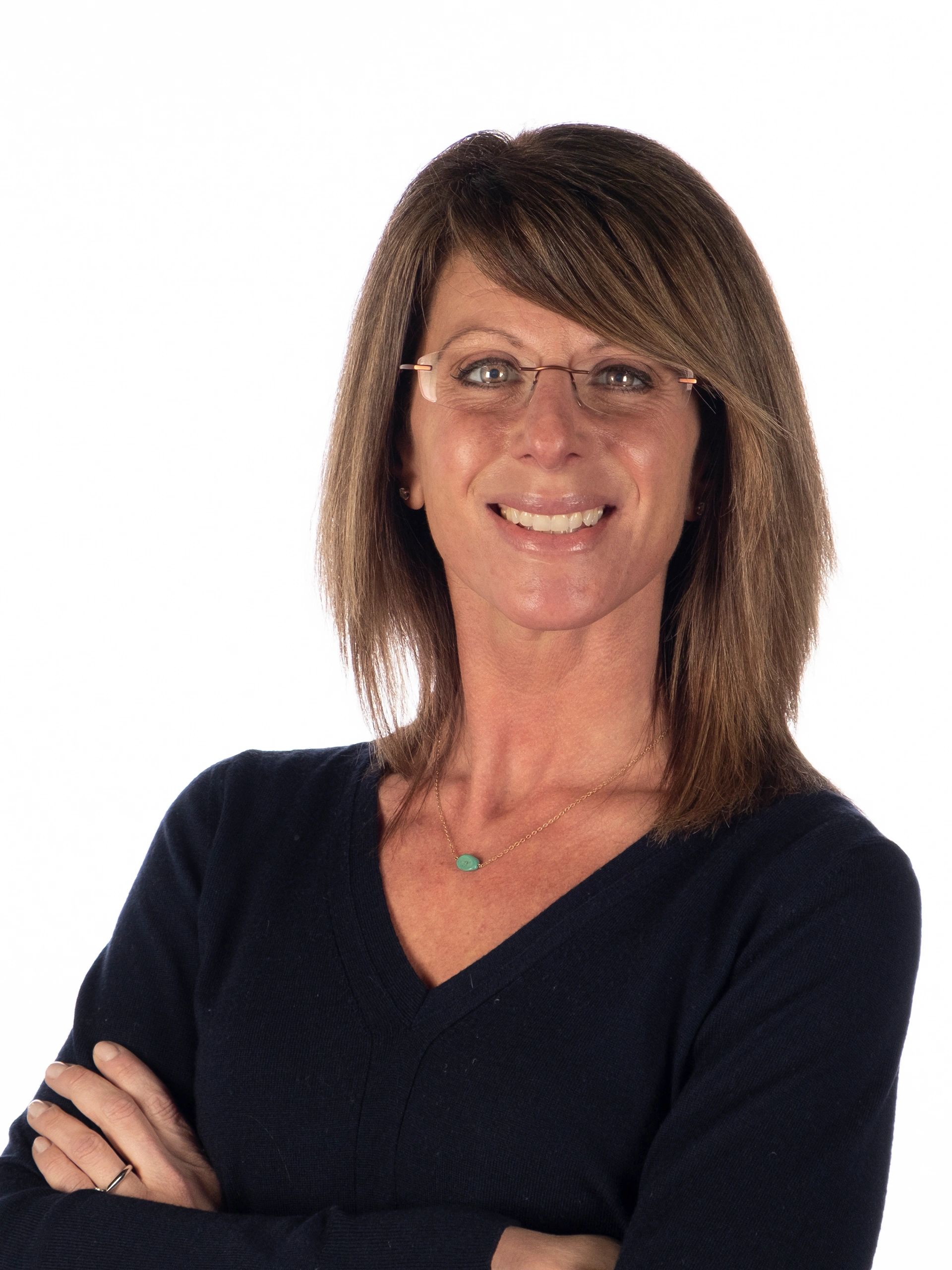 Smiling woman with glasses and crossed arms.