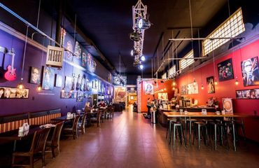 Interior of a cozy music-themed café with guitars and photos on the walls.