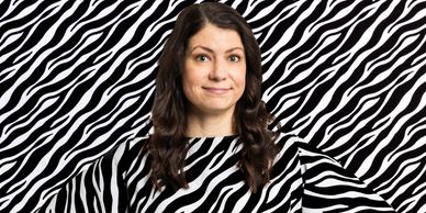 Woman in a black and white striped outfit against a matching striped background.