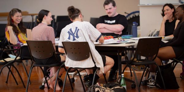 Group discussion around a table in a casual setting.