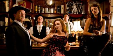 Group of people in vintage attire at a bar.