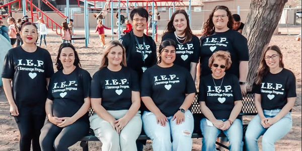 Classroom teachers wearing their custom shirts for a photo for special kids they teach. 